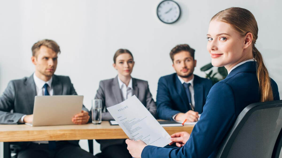Eine Bewerberin beim Vorstellungsgespräch, zuversichtlich in die Kamera schauen