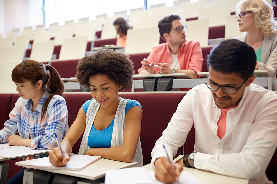 einstellungstest-duales-studium-group-of-students-with-notebooks-in-lecture-hall-pmqylfc